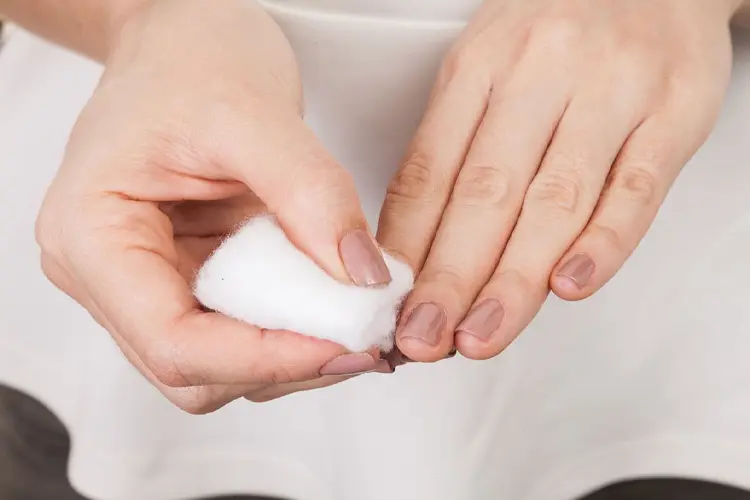 Ongles abîmés : signes d’alerte à ne pas négliger - Femme retirant du vernis