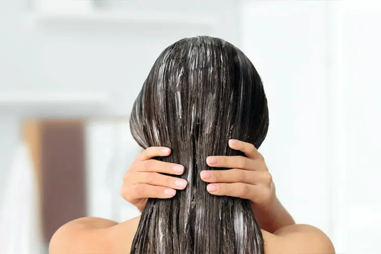 Soins capillaires : conseils d’un médecin pour des cheveux brillants - image d’une chevelure avec masque posé et serviette enroulée